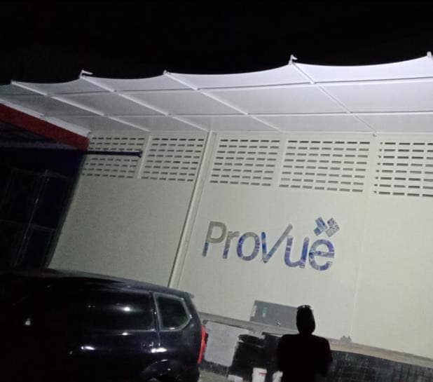 Kanopi membrane putih di depan gedung kantor pada malam hari
