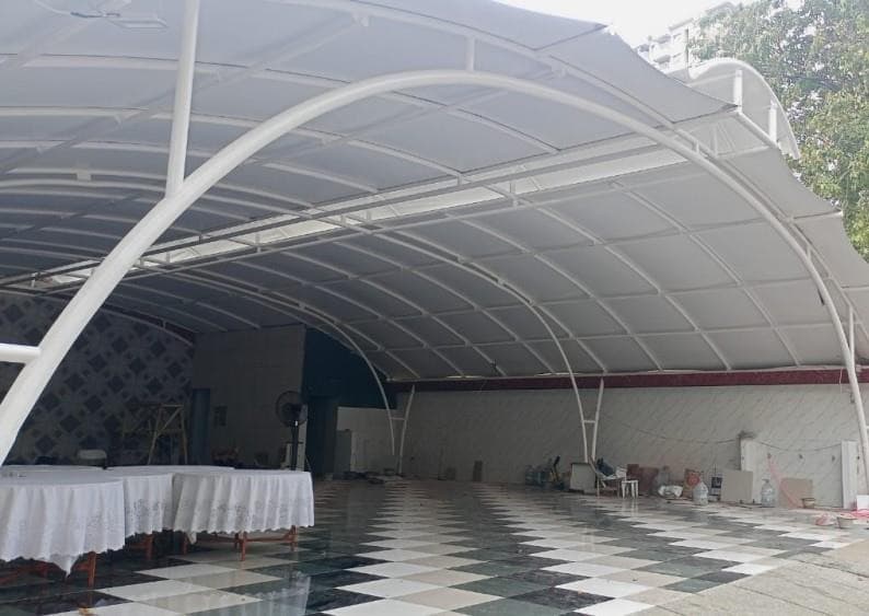 Kanopi membrane rangka lengkung menaungi area berlantai keramik