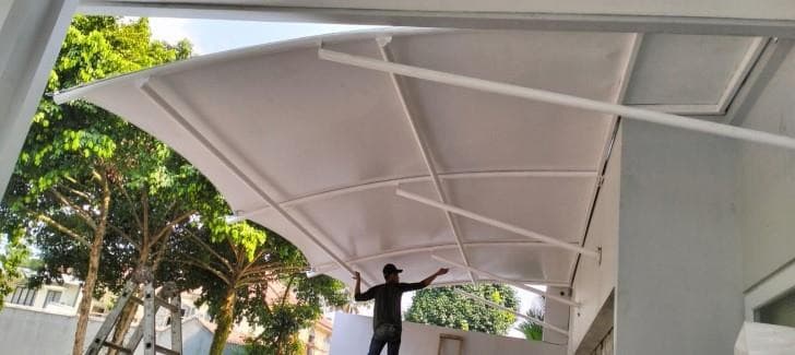 Teknisi merapikan membrane kanopi yang baru terpasang