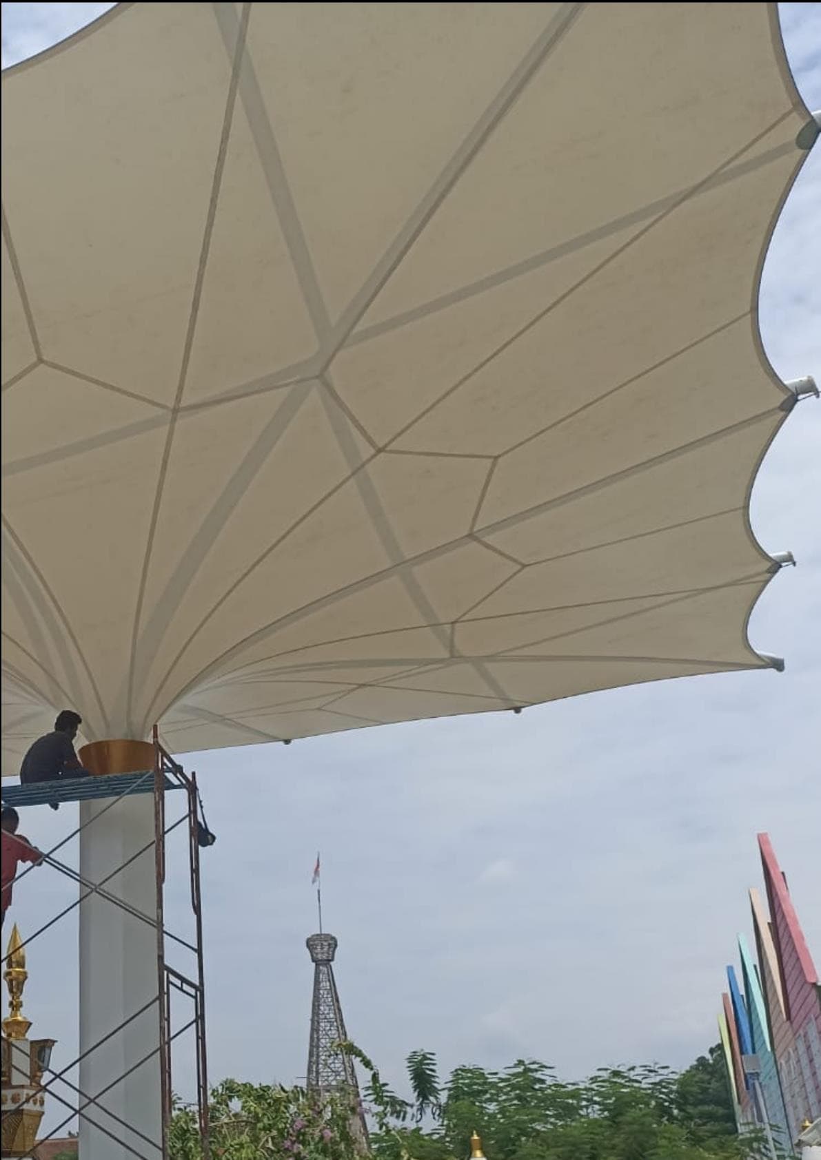 Kanopi membrane model payung berukuran besar dengan teknisi di atas scaffolding