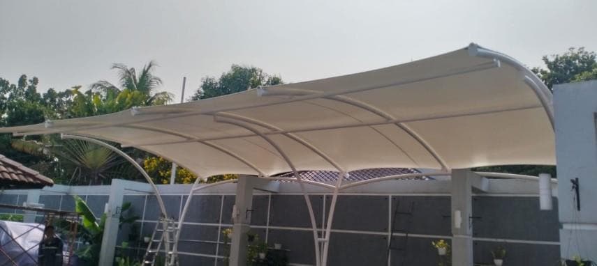 Kanopi membrane berangka lengkung putih di atas carport